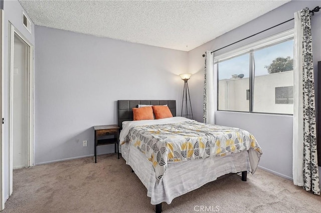 carpeted bedroom featuring a textured ceiling