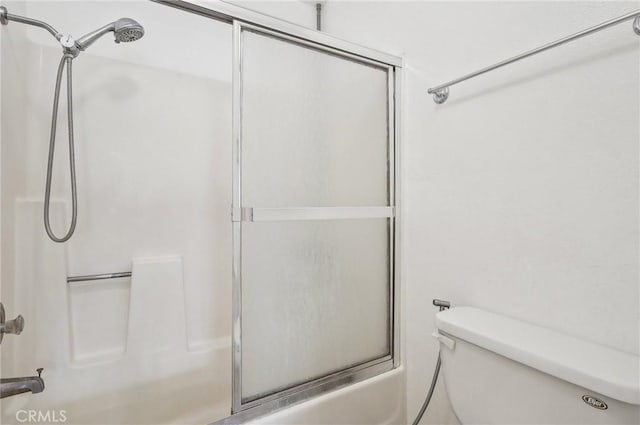 bathroom featuring bath / shower combo with glass door and toilet