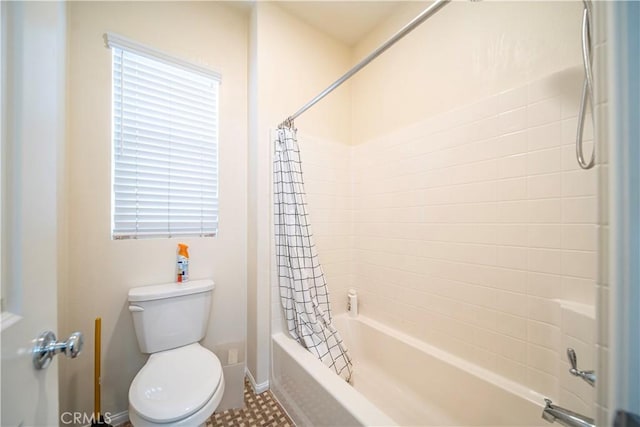 bathroom featuring shower / bath combo, a healthy amount of sunlight, and toilet