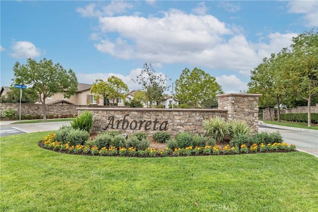 community / neighborhood sign featuring a lawn