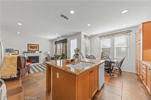 kitchen with sink, dishwasher, a kitchen island with sink, light stone counters, and light tile patterned flooring