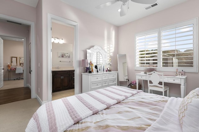 bedroom featuring ceiling fan, ensuite bath, and sink