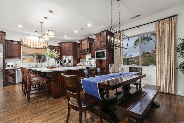 dining room featuring sink, dark hardwood / wood-style floors, and a chandelier