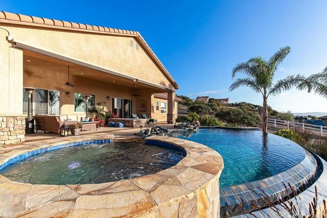 view of pool with an outdoor hangout area, a patio area, and ceiling fan