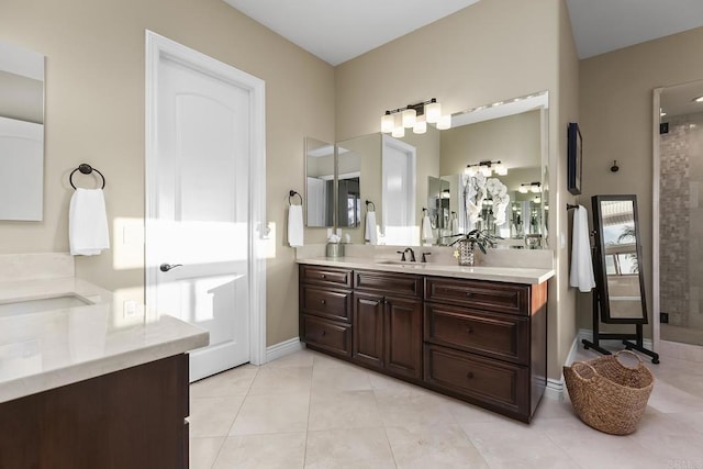 bathroom with tile patterned flooring, vanity, and walk in shower