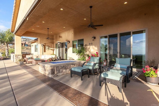 view of patio / terrace with an outdoor living space with a fire pit and ceiling fan