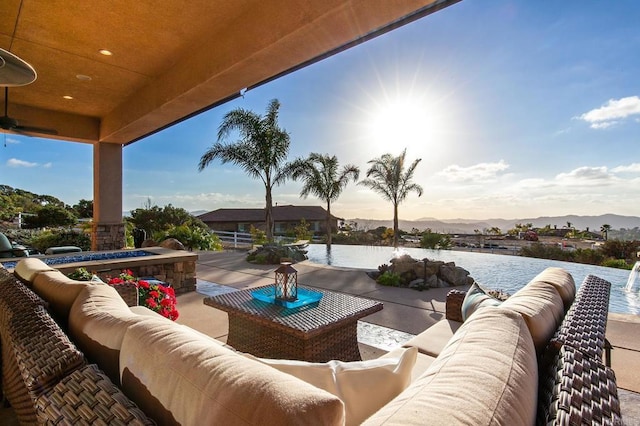 view of patio with an outdoor living space and a water and mountain view