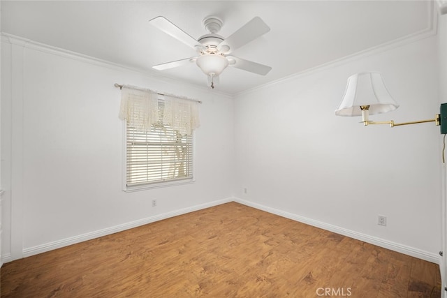 empty room with wood finished floors, baseboards, ornamental molding, and ceiling fan