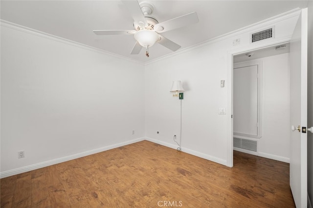 empty room featuring ornamental molding, ceiling fan, wood finished floors, and visible vents