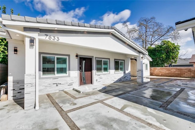 7631 Columbia St, Rosemead, CA 91770 - rear view of house featuring fence, stone siding, a patio area, and stucco siding
