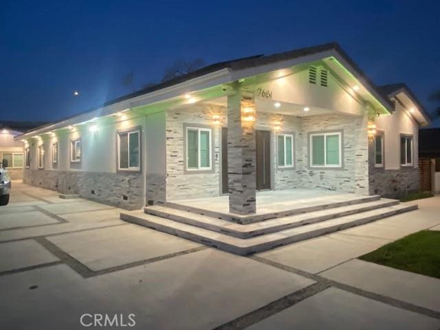 7631 Columbia St, Rosemead, CA 91770 - back of house at night featuring stone siding and a patio