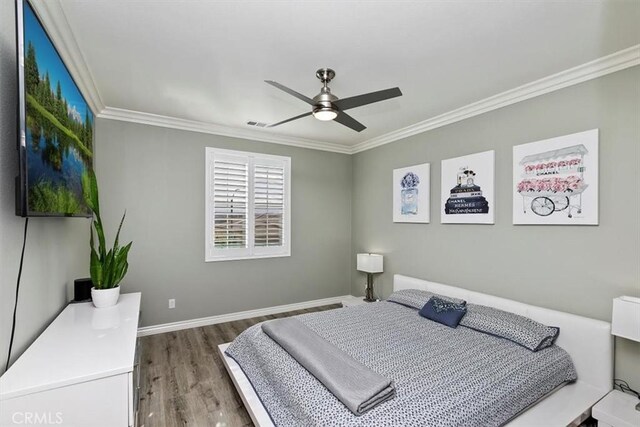 bedroom with ornamental molding, wood-type flooring, and ceiling fan