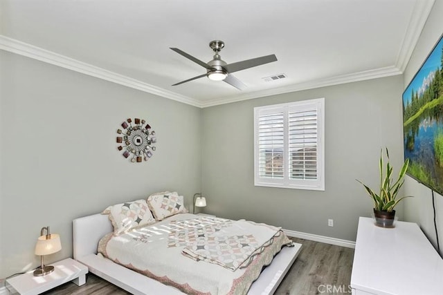 bedroom with hardwood / wood-style flooring, ornamental molding, and ceiling fan