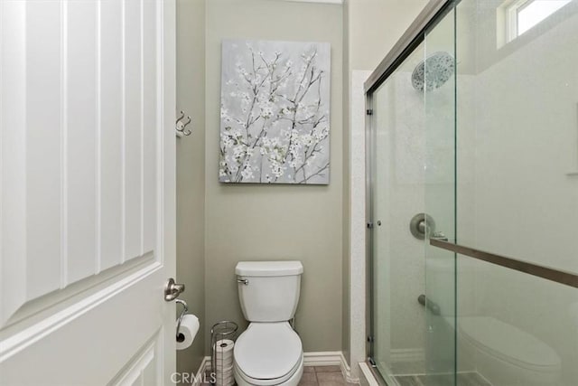 bathroom featuring walk in shower, toilet, and tile patterned flooring