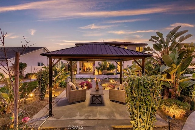 patio terrace at dusk featuring a gazebo and an outdoor hangout area