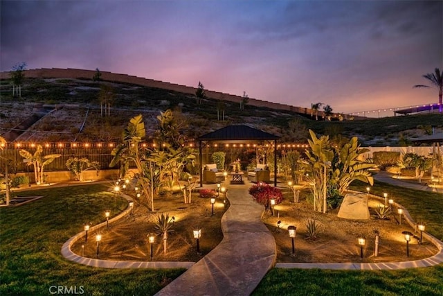 patio terrace at dusk with a gazebo and a yard