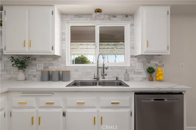 kitchen featuring sink, dishwasher, tasteful backsplash, light stone counters, and white cabinets