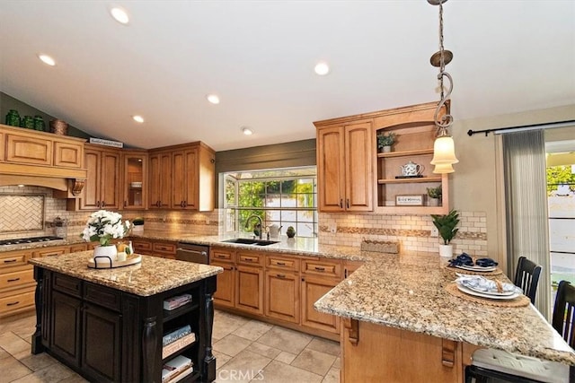 kitchen featuring light stone counters, sink, and a center island