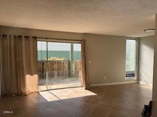 unfurnished living room featuring a textured ceiling and a water view