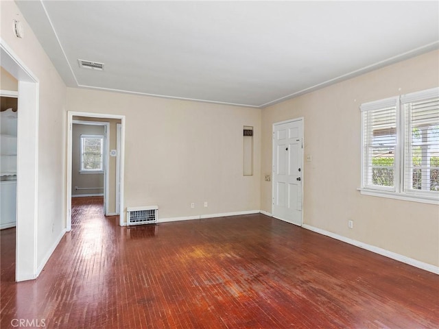 spare room with dark hardwood / wood-style flooring and heating unit