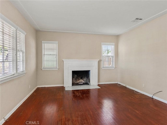 unfurnished living room with hardwood / wood-style flooring and a brick fireplace