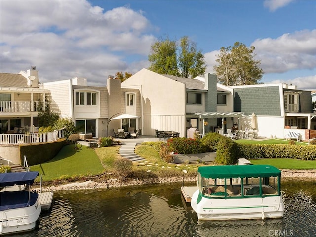 rear view of property featuring a patio, a water view, a lawn, and a pergola