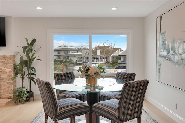 dining room with baseboards, light wood-type flooring, and recessed lighting