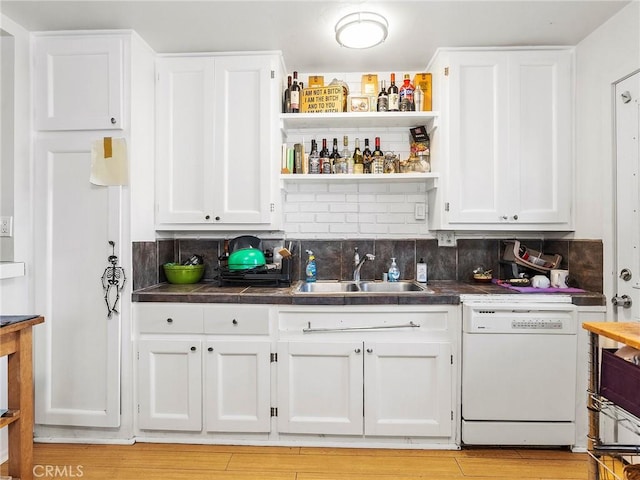 kitchen featuring sink, backsplash, white cabinets, white dishwasher, and light hardwood / wood-style floors