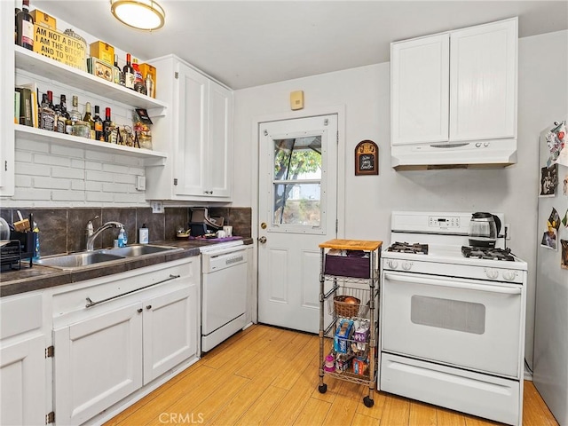 kitchen featuring sink, white cabinetry, light wood-type flooring, white appliances, and backsplash