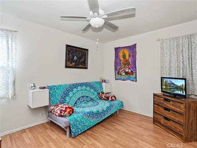 living area with ceiling fan and wood-type flooring