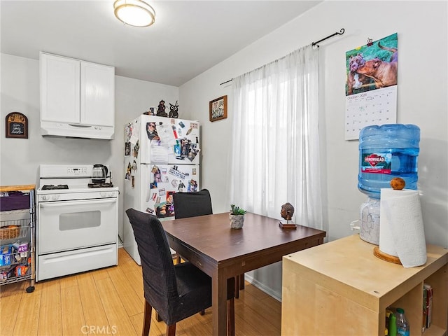 kitchen with white appliances, light hardwood / wood-style flooring, and white cabinets