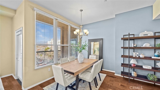 dining area featuring dark wood-type flooring and a chandelier