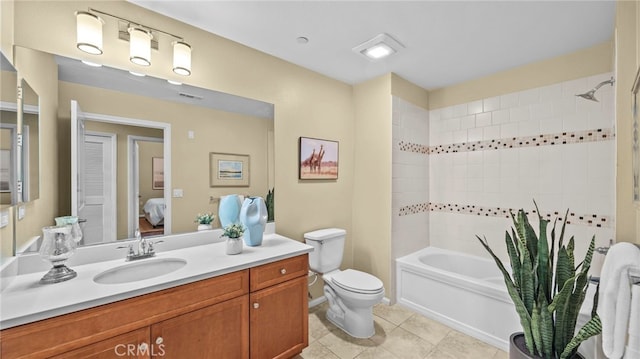 full bathroom featuring vanity, tiled shower / bath, toilet, and tile patterned floors