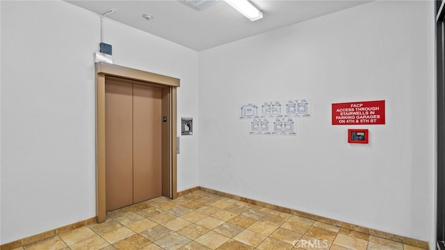 unfurnished room featuring elevator