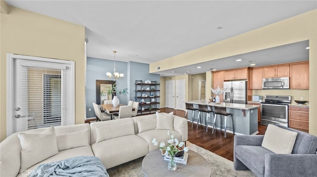 living room featuring dark hardwood / wood-style floors and an inviting chandelier