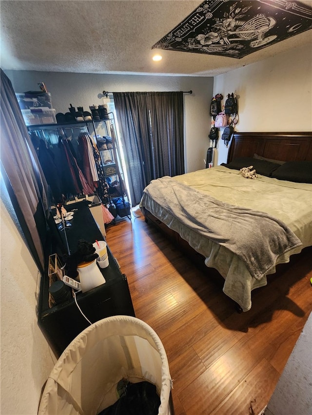 bedroom with hardwood / wood-style floors and a textured ceiling