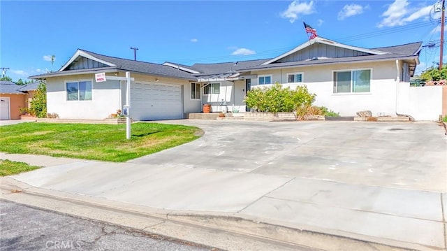 ranch-style home with driveway, an attached garage, board and batten siding, and a front yard