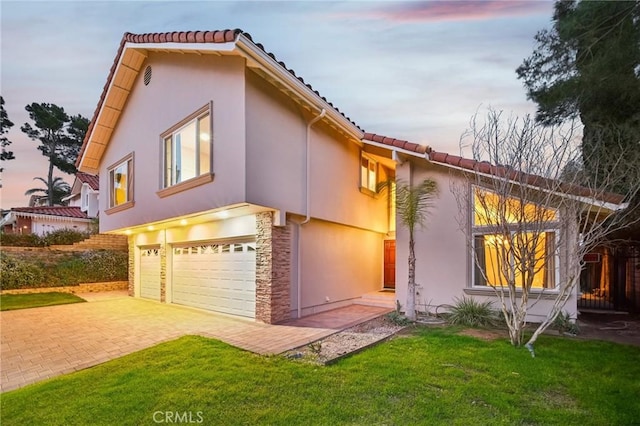 view of front of home with a garage and a lawn