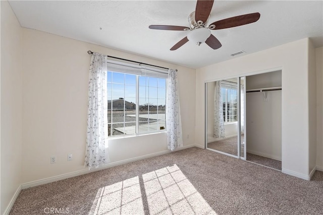 unfurnished bedroom featuring light carpet, a closet, and ceiling fan