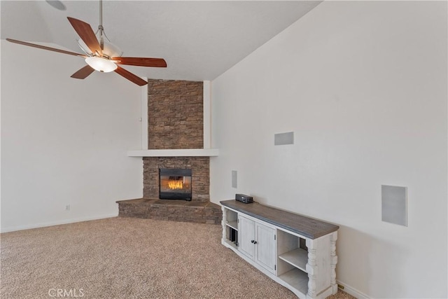 unfurnished living room with ceiling fan, light colored carpet, a fireplace, and vaulted ceiling