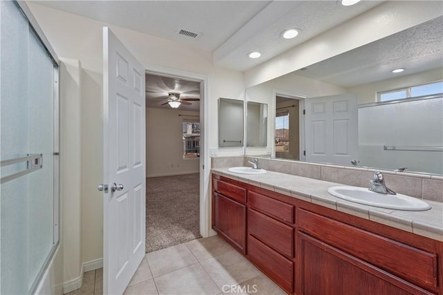 bathroom featuring a shower with door, vanity, and tile patterned floors