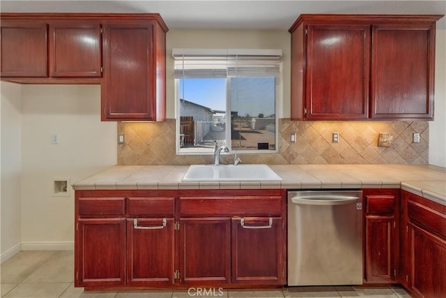 kitchen with tasteful backsplash, sink, tile counters, and stainless steel dishwasher