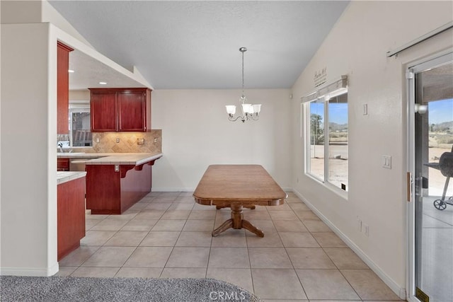 tiled dining space with lofted ceiling and a chandelier