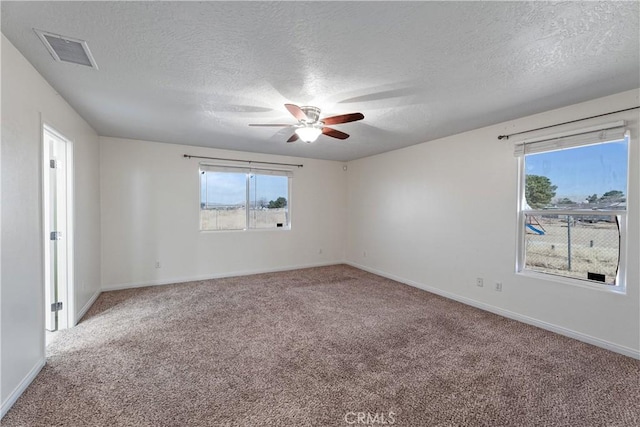 carpeted empty room featuring ceiling fan and a textured ceiling