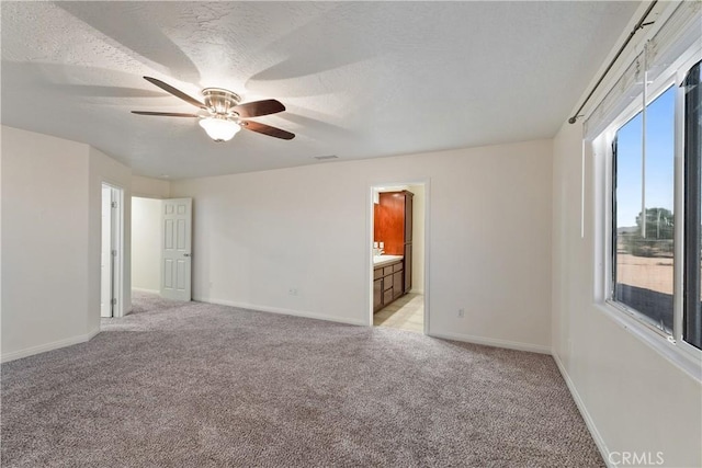 empty room featuring light carpet, ceiling fan, and a textured ceiling