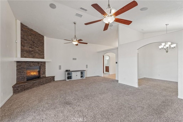 unfurnished living room with ceiling fan with notable chandelier, high vaulted ceiling, light colored carpet, and a fireplace