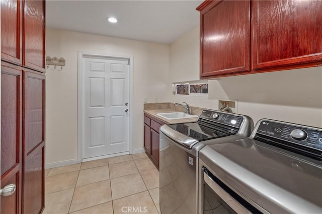 laundry room featuring independent washer and dryer, cabinets, light tile patterned flooring, and sink