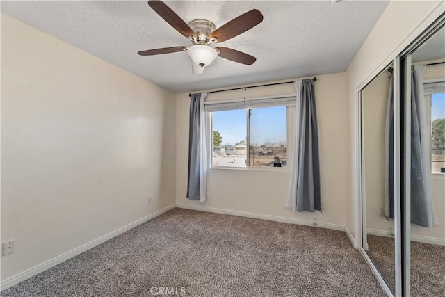 unfurnished room with ceiling fan, carpet, and a textured ceiling