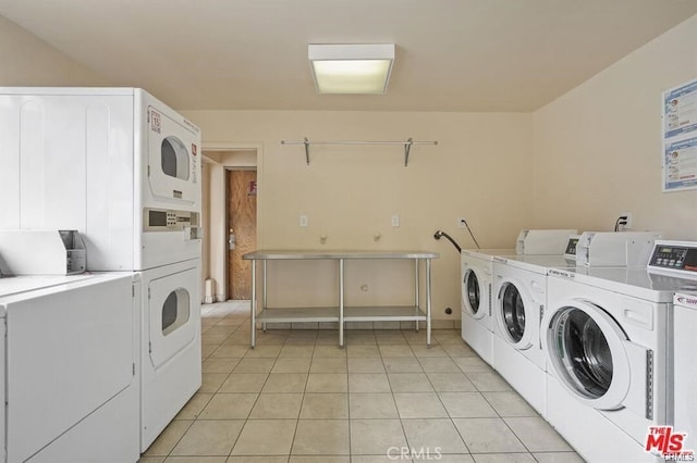 washroom featuring stacked washing maching and dryer, light tile patterned flooring, and washing machine and clothes dryer