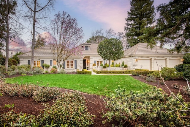 view of front of property with a garage and a lawn